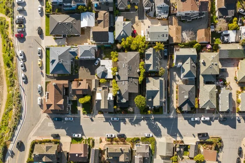 A bird 's eye view of houses and cars on the street.