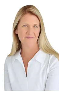 A woman with long blonde hair wearing a white shirt.