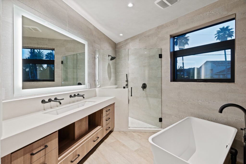 A bathroom with a large mirror and a tub.