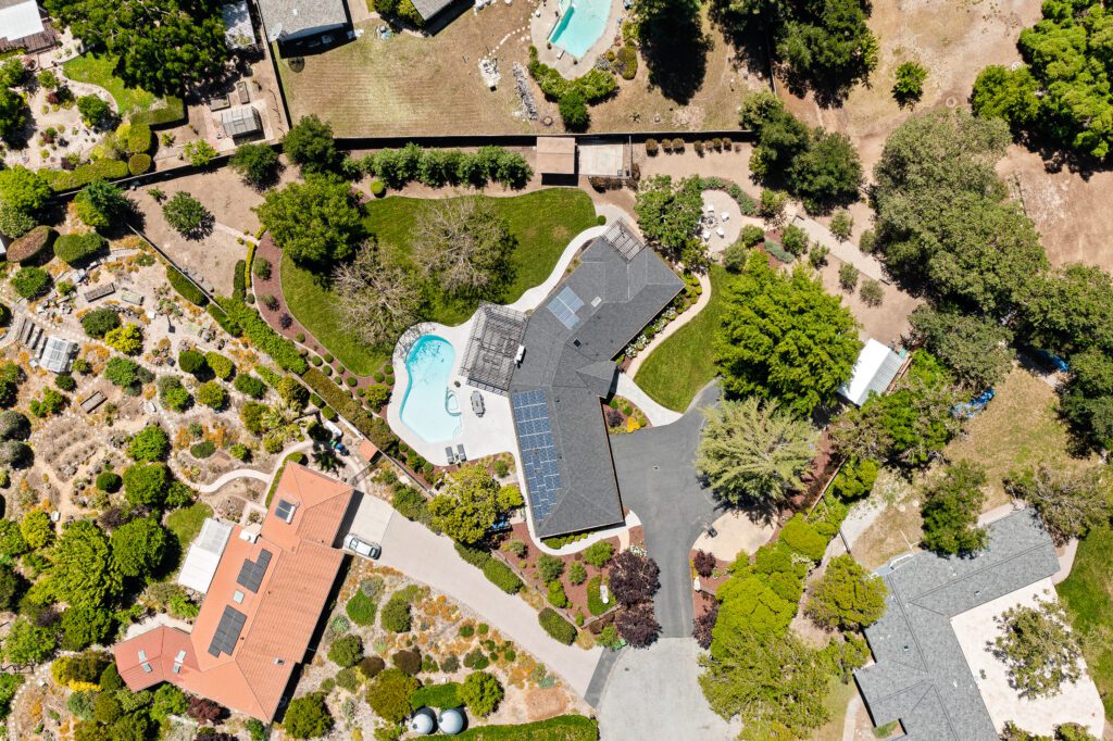 A bird 's eye view of a house with a pool and trees.