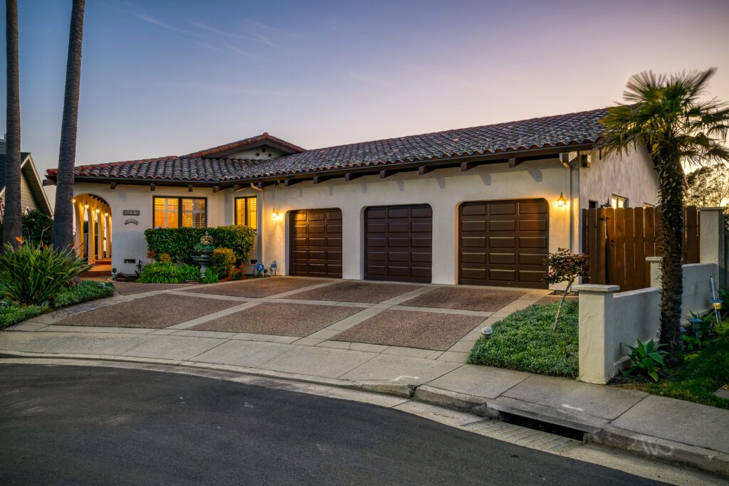 A home with three garage doors and a driveway.